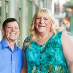 Happy middle aged transgender couple standing together outside in urban setting